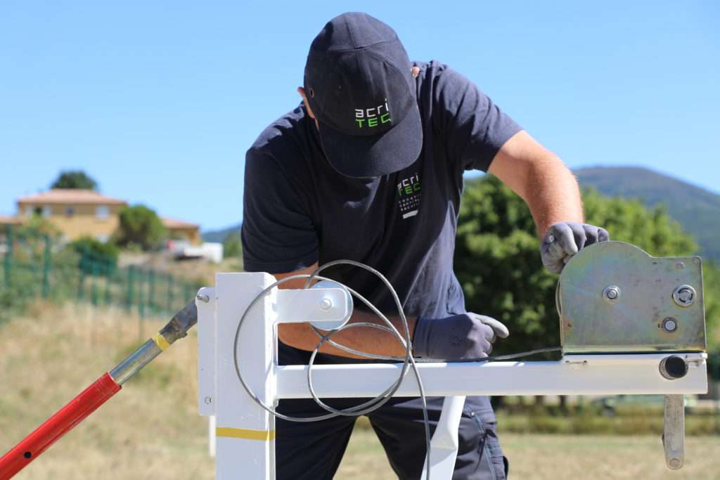 Technicien acritec en train de contrôler un équipement sportif d'une aire de jeux